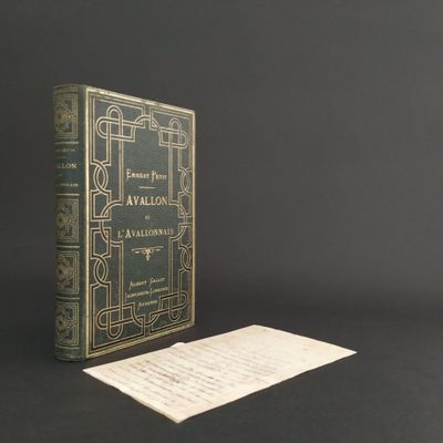 an old book sitting on a table next to a piece of paper
