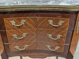 a small chest of drawers with a marble top