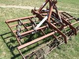 a rusted plow sitting in the grass on the field