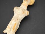 une figurine antique représentant une femme coiffée d'un chapeau