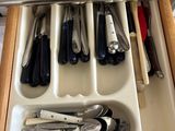 a drawer with utensils and spoons in it