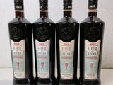 Quatre bouteilles d'alcool sont alignées sur une table