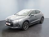 Une Citroën grise est garée dans une pièce au sol noir.