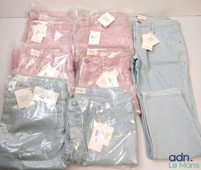 Plusieurs paires de jeans sont posées sur une table, dans des sacs en plastique.