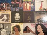 many different album covers on the wall of a room