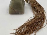 a stone and rope on a white surface