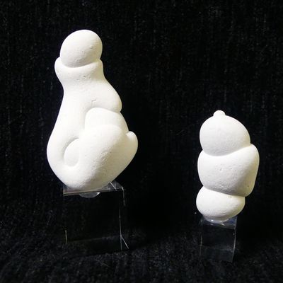 two white sculptures of a cat and a bear on a black background