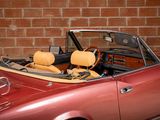 an image of a red convertible car parked in front of a brick wall