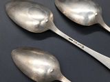 three spoons that are sitting on a table