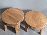 two small wooden stools sitting next to each other on a gray surface