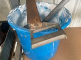 a blue bucket with a knife in it on a table