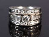a close up of a diamond ring on a black surface