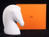 une statue représentant une tête de cheval blanc, à côté d'une boîte orange