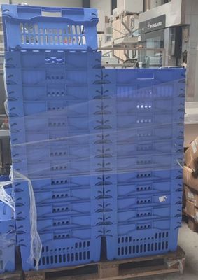 de nombreuses caisses bleues empilées sur une palette dans un entrepôt