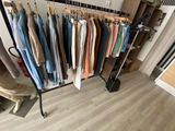 a rack of clothes hanging on a clothes rack in a room
