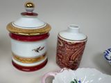 a white and red vase and a white and gold container