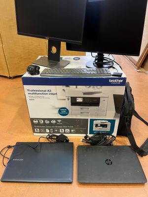 two monitors and a laptop sitting on top of a wooden table