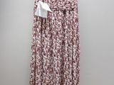 a woman ' s skirt hanging on a hanger in front of a white wall