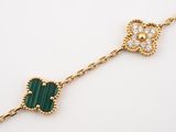 a close up of a bracelet with a green heart on it