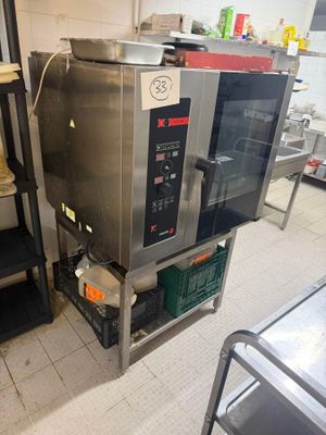 a silver microwave sitting on a metal shelf in a kitchen