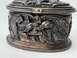 a silver box with a bird on it on a table