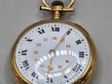 a gold pocket watch with roman numerals on it