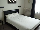 un lit avec des draps blancs et une tête de lit noire dans une chambre