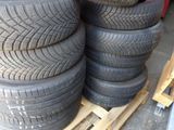 tires stacked on a pallet in a garage with a red wall