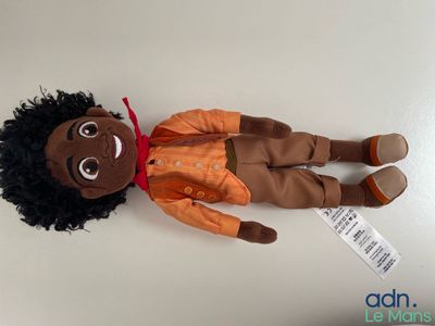 stuffed toy of a person laying on a table with a price tag