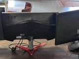 three computer monitors sitting on top of a wooden table