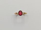 une bague en or avec une pierre rouge au centre