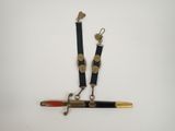 a close up of a knife and a pen on a white surface