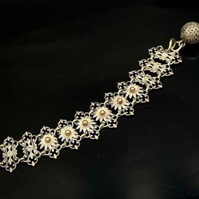 bracelet en argent orné de fleurs et de perles sur un fond noir