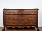 une commode ancienne posée sur un parquet