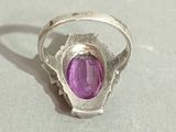 silver ring with a purple stone in the middle of it