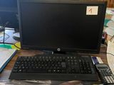 un bureau sur lequel se trouvent un écran, un clavier, une souris et d'autres éléments