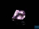 a close up of a pink diamond on a black surface