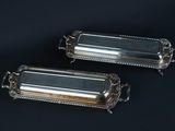 pair of silverplated rectangular trays on black background