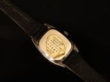 a close up of a watch on a black surface