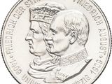 les deux hommes se tiennent côte à côte sur une pièce de monnaie