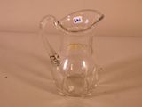 a clear glass pitcher with a handle on a table