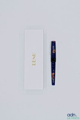 a pen that is laying next to a white box