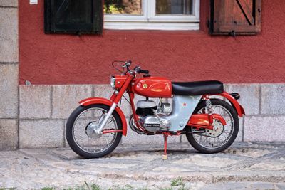 une moto rouge garée devant un immeuble rouge