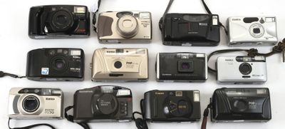 de nombreux modèles d'appareils photo alignés sur une surface blanche