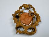 a picture of a brooch with a tag on it