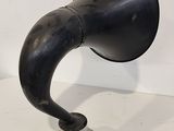 a black horn on a metal stand on a white surface