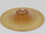 a yellow plate with a brown lid on a white table