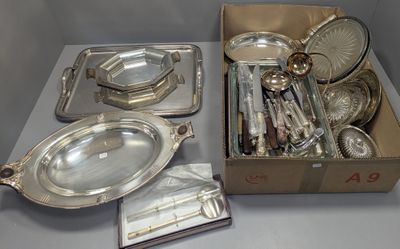 une boîte de couverts posée sur une table, à côté d'une autre boîte de couverts