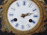 une statue d'un homme assis au sommet d'une horloge