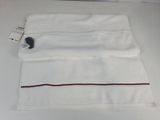 towels on a table with a tag on it and a pair of scissors in the middle